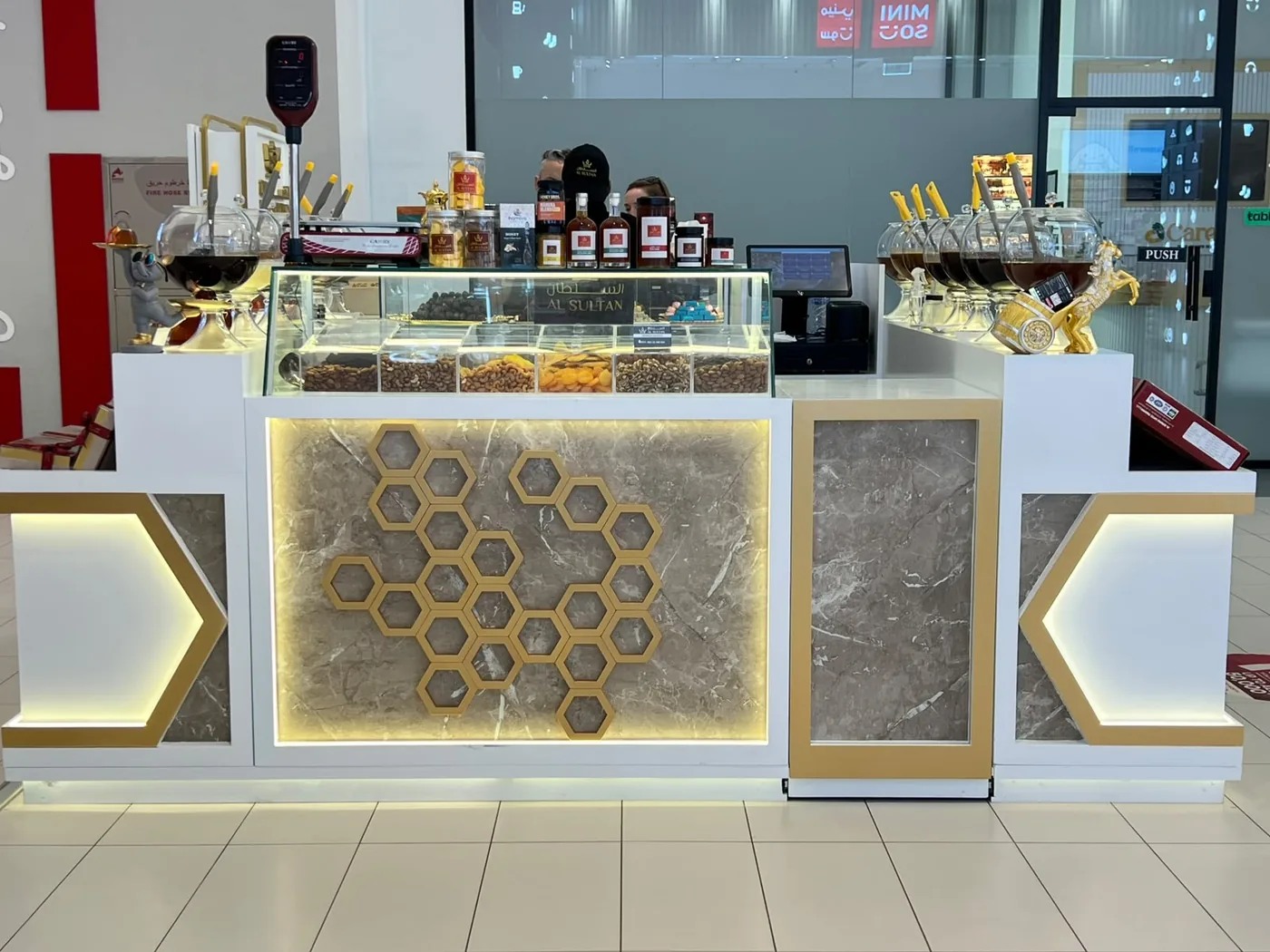 Al Sultan Honey kiosk at Lulu Mall Umm Al Quwain with a backlit honeycomb feature panel
